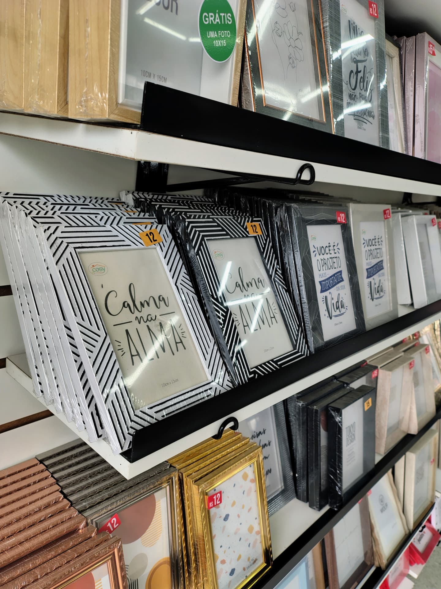 Prateleiras com porta-retratos decorativos na loja da Speedy Gráfica
