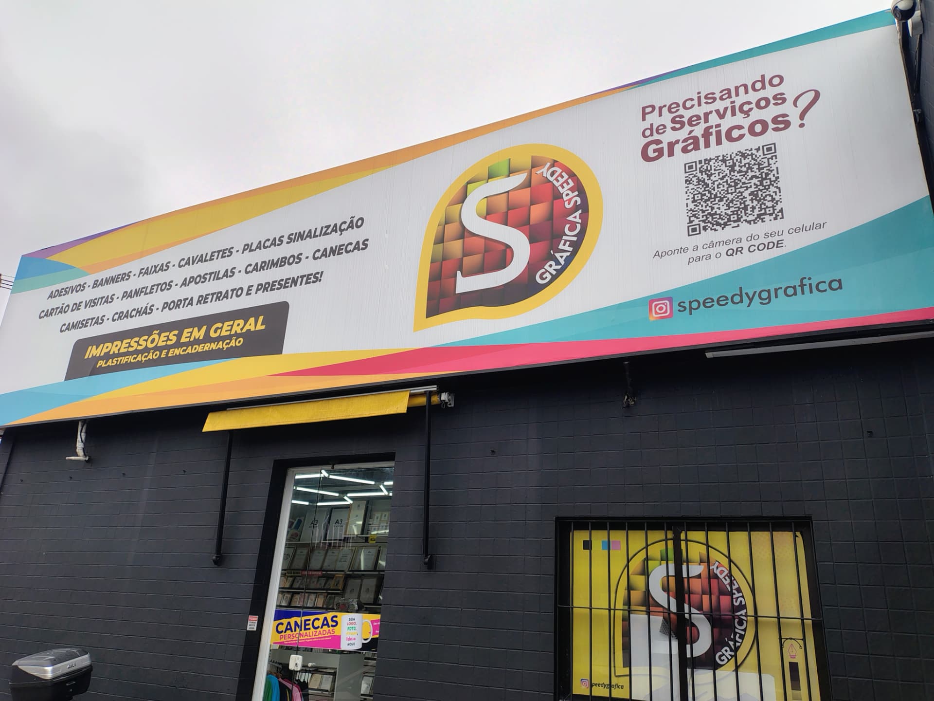 Entrada e vitrines da Speedy Gráfica com produtos expostos